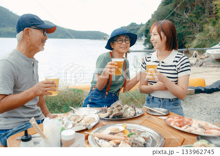 海辺で親子三人の乾杯シーン 133962745
