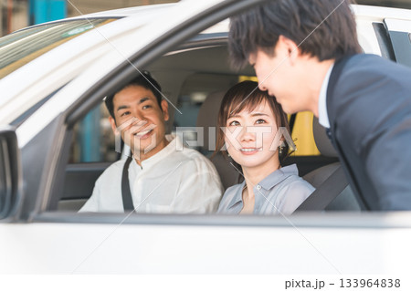 自動車購入・査定・買取にきた顧客を接客するセールスマンの若いアジア人男性 自動車購入・査定・買取にきた顧客を接客するセールスマンの若いアジア人男性 133964838