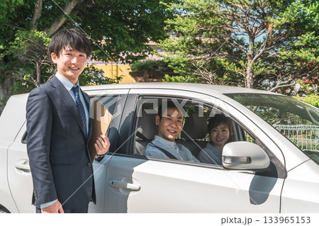 自動車購入・査定・買取にきた顧客を接客するセールスマンの若いアジア人男性 133965153