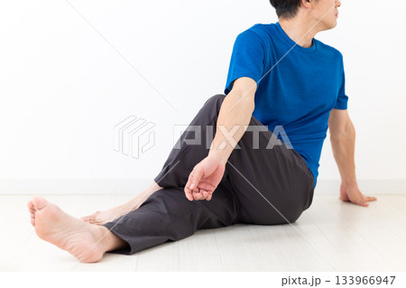 足のストレッチ体操をするTシャツ姿のミドル男性 足のストレッチ体操をするTシャツ姿のミドル男性 133966947