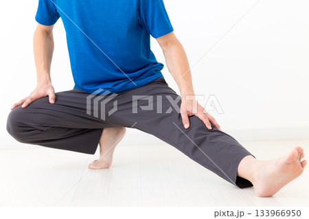 足のストレッチ体操をするTシャツ姿のミドル男性 133966950