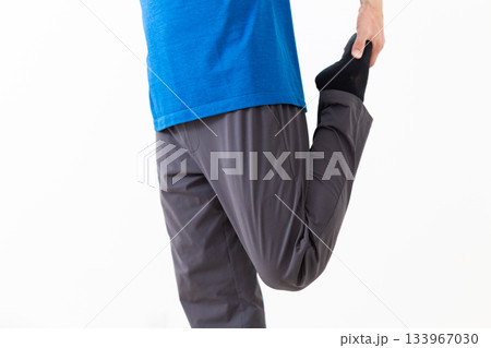 足のストレッチ体操をするTシャツ姿のミドル男性 133967030
