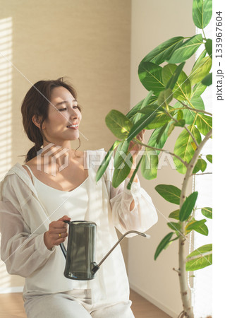観葉植物に水やりをするおしゃれな若いアジア人女性 観葉植物に水やりをするおしゃれな若いアジア人女性 133967604