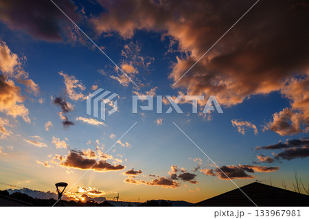 生駒山系に沈んで行く夕日と大空に広がった夕焼け雲 奈良市内の公園にて 生駒山系に沈んで行く夕日と大空に広がった夕焼け雲 奈良市内の公園にて 133967981