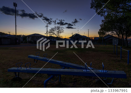 誰もいない奈良市内の公園で夕焼けの残照に照らされるシーソー 誰もいない奈良市内の公園で夕焼けの残照に照らされるシーソー 133967991