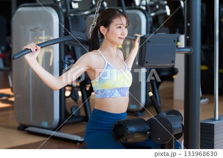 スポーツジムでトレーニングする若い女性 スポーツジムでトレーニングする若い女性 133968630