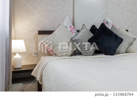 Soft Bedroom Pillows and Warm Lamp Interior Detail 133968764