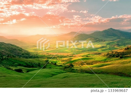 beautiful green valley with green fields with green spring grass with nive hills and mountains and scrnic colorful cloudy sunset on background of landscape 133969687