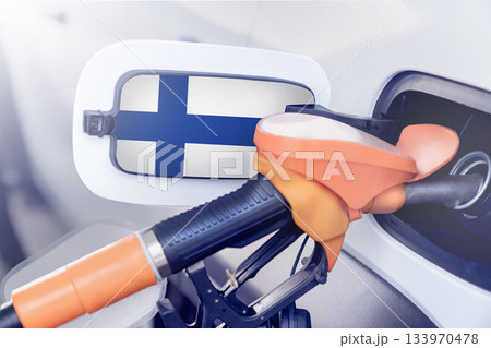 Finland flag on the lid of the gas tank of a car at a gas station in close-up. High or low prices for gasoline and diesel fuel at Finnish gas stations. There is a shortage of fuel for cars and fuel in Finland flag on the lid of the gas tank of a car at a gas station in close-up. High or low prices for gasoline and diesel fuel at Finnish gas stations. There is a shortage of fuel for cars and fuel in 133970478