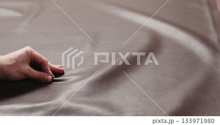 man hand checking brown leather piece closeup man hand checking brown leather piece closeup 133971980