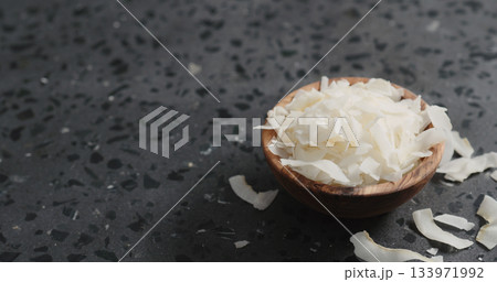 coconut chips in olive bowl on terrazzo surface 133971992