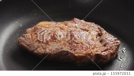 Closeup shot of ribeye steak frying on non stick pan Closeup shot of ribeye steak frying on non stick pan 133972031