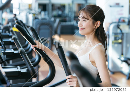 スポーツジムでトレーニングする若い女性 スポーツジムでトレーニングする若い女性 133972083