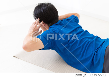 背筋の筋トレをするTシャツ姿のミドル男性 背筋の筋トレをするTシャツ姿のミドル男性 133972265
