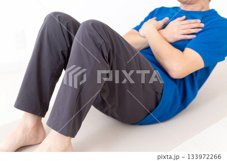 腹筋の筋トレをするTシャツ姿のミドル男性 腹筋の筋トレをするTシャツ姿のミドル男性 133972266