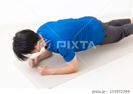プランクの筋トレをするTシャツ姿のミドル男性 133972269