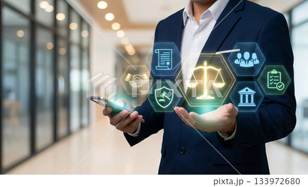 Businessman hand holding smartphone with legal justice icons and balance scale hologram. 133972680