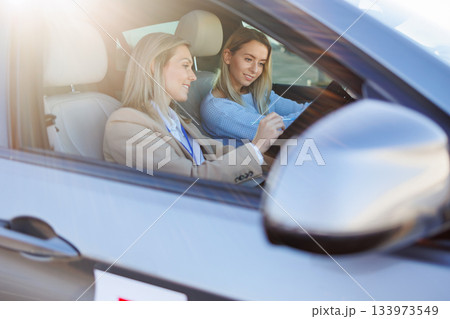 Driving Instructor Explaining Evaluation Sheet to Learner Driver 133973549