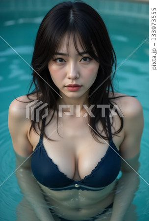 紺色のビキニでプールに入っている女性が真剣な表情で見上げる 133973555