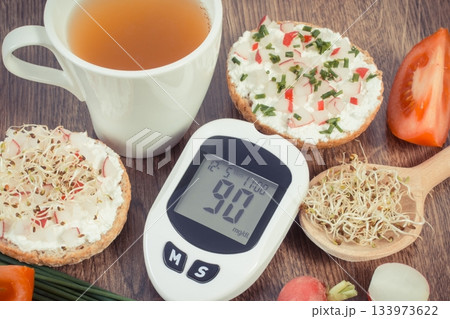 Glucometer with sugar level, freshly breakfast with tea. Healthy nutrition during diabetes Glucometer with sugar level, freshly breakfast with tea. Healthy nutrition during diabetes 133973622