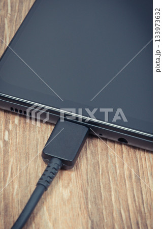 Smartphone and connected cable of charger. Telephone charging Smartphone and connected cable of charger. Telephone charging 133973632