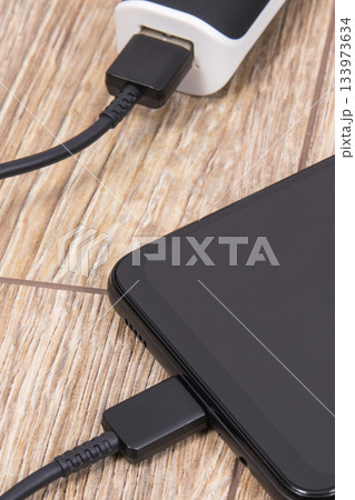 External powerbank using to charge empty battery of black smartphone External powerbank using to charge empty battery of black smartphone 133973634
