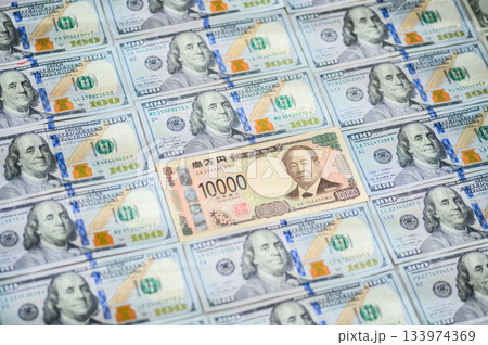 日本の一万円札を主役にした米100ドル紙幣の傾き構図クローズアップ 133974369