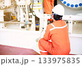 Technician monitor and command by radio to operator on job site in oil and gas industry, Worker in oil and gas industry contact to operation team to check condition of the machine, with warm light. 133975835