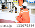 Technician monitor and command by radio to operator on job site in oil and gas industry, Worker in oil and gas industry contact to operation team to check condition of the machine. 133975836