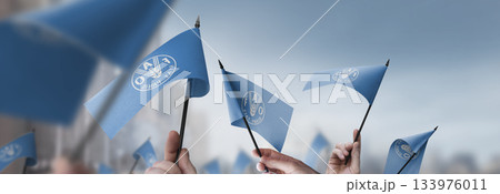 Food and agriculture organization flags in their hands on a blurred urban background 133976011