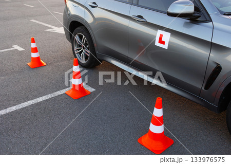 Close View of Driving School Car and Traffic Cones on Practice Ground 133976575
