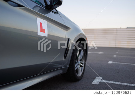 Car with Learner Driver Sign Parked on Training Ground 133976625