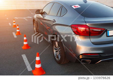 Learner Vehicle Maneuvering Between Safety Cones on Driving Test Area 133976626