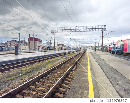 Isolated train platform with approaching regional train and overhead wiring Isolated train platform with approaching regional train and overhead wiring 133976867