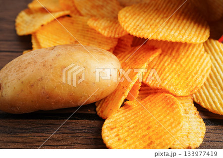 Potato chips in open bag, delicious BBQ seasoning spicy for crips, thin slice deep fried snack fast food. Potato chips in open bag, delicious BBQ seasoning spicy for crips, thin slice deep fried snack fast food. 133977419