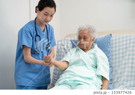 Asian doctor checking and treat elderly woman patient health in hospital. 133977426