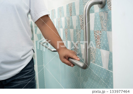 Asian woman patient use toilet support rail in bathroom, handrail safety grab bar, security in nursing hospital. Asian woman patient use toilet support rail in bathroom, handrail safety grab bar, security in nursing hospital. 133977464