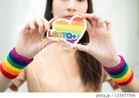Asian woman holding LGBT heart with rainbow flag. 133977566
