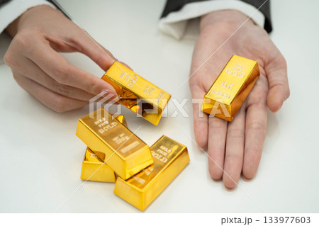 Asian woman holding gold bar in finance business. Asian woman holding gold bar in finance business. 133977603