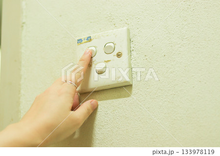 古い電気スイッチを操作する女性の手元 古い電気スイッチを操作する女性の手元 133978119