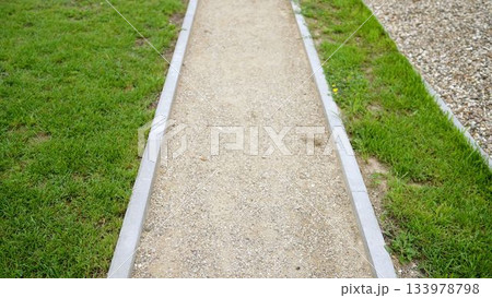 Gravel path and green grass in park 133978798