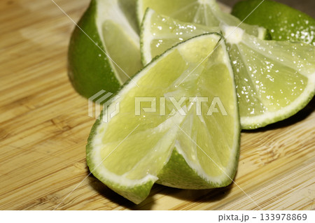 Close up of chopped sliced lime pieces on a chopping board Close up of chopped sliced lime pieces on a chopping board 133978869