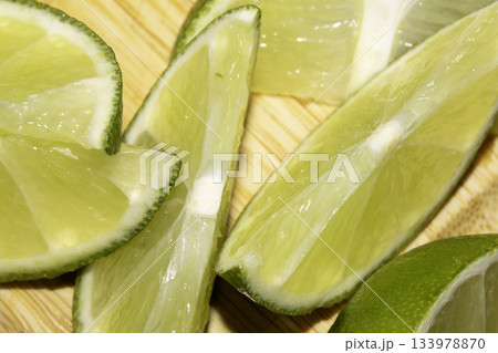 Close up of chopped sliced lime pieces on a chopping board Close up of chopped sliced lime pieces on a chopping board 133978870
