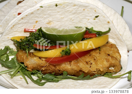 A very tasty fried pineapple taco with peppers and lime street food fresh meal 133978878