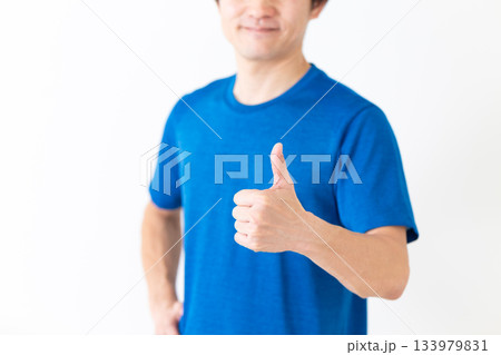 ガッツポーズをするTシャツ姿のミドル男性 133979831