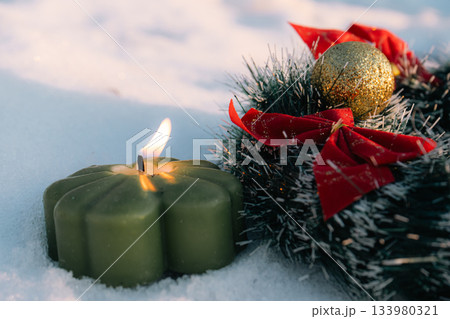 Green Candle and Christmas Wreath in Snow - Winter Holiday Scene Green Candle and Christmas Wreath in Snow - Winter Holiday Scene 133980321