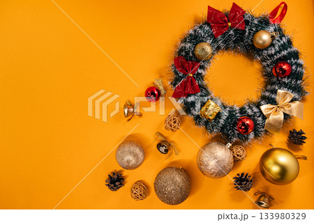 Holiday decoration featuring a Christmas wreath with ornaments and bows Holiday decoration featuring a Christmas wreath with ornaments and bows 133980329