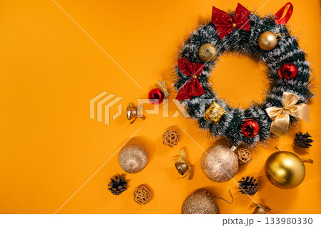 Holiday decoration featuring a Christmas wreath with ornaments and bows Holiday decoration featuring a Christmas wreath with ornaments and bows 133980330