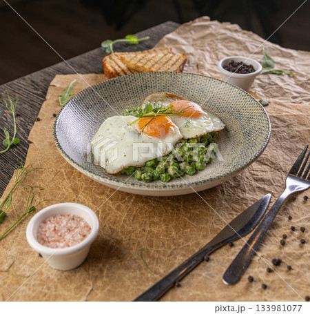 Plate of fried eggs on green peas puree Plate of fried eggs on green peas puree 133981077