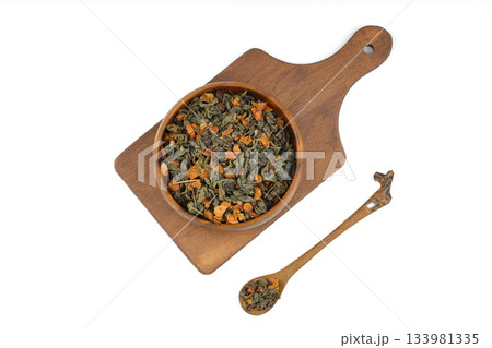 A pile of dry green tea on a white background. Apple flavor. Top view, isolated, close-up. A pile of dry green tea on a white background. Apple flavor. Top view, isolated, close-up. 133981335
